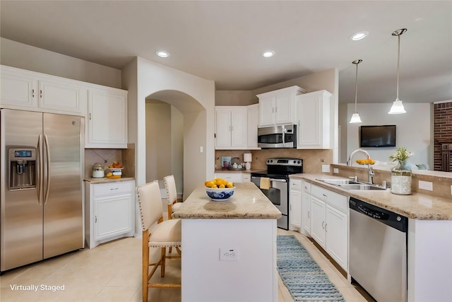 kitchen featuring pendant lighting, sink, a breakfast bar area, appliances with stainless steel finishes, and kitchen peninsula