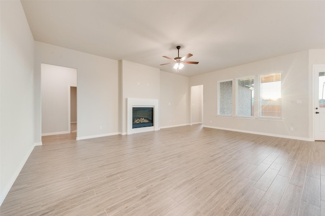 unfurnished living room featuring ceiling fan and light hardwood / wood-style flooring