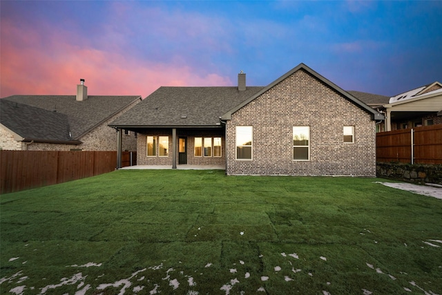 back house at dusk with a yard