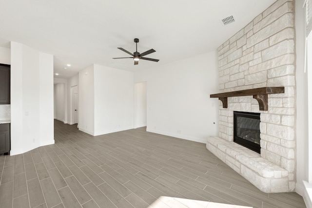 unfurnished living room with a fireplace, ceiling fan, and hardwood / wood-style floors