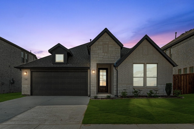 view of front of property with a garage and a lawn