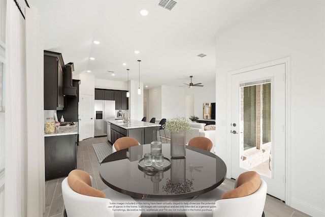 tiled dining area featuring ceiling fan and sink