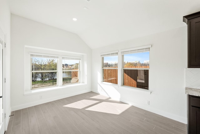 interior space with a water view and lofted ceiling