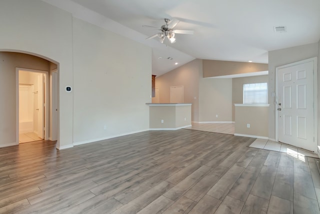 unfurnished living room featuring ceiling fan, light hardwood / wood-style floors, and vaulted ceiling