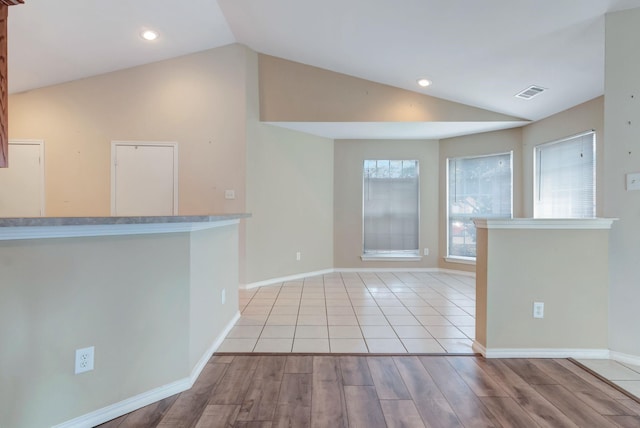 interior space with light hardwood / wood-style floors and vaulted ceiling