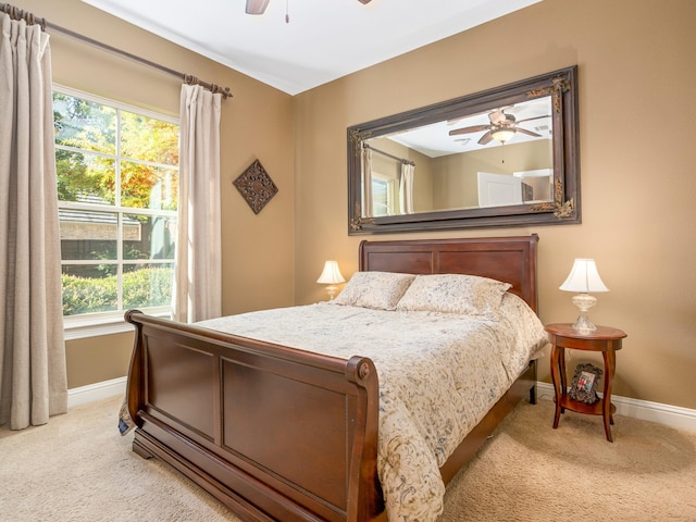 carpeted bedroom featuring ceiling fan and multiple windows