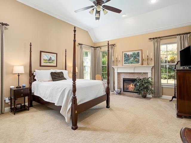 bedroom featuring multiple windows, lofted ceiling, ceiling fan, and light carpet