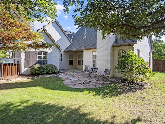 7005 Shinnecock Hills Dr, Fort Worth, TX 76132 - rear view of house featuring a patio, brick siding, fence, and a lawn