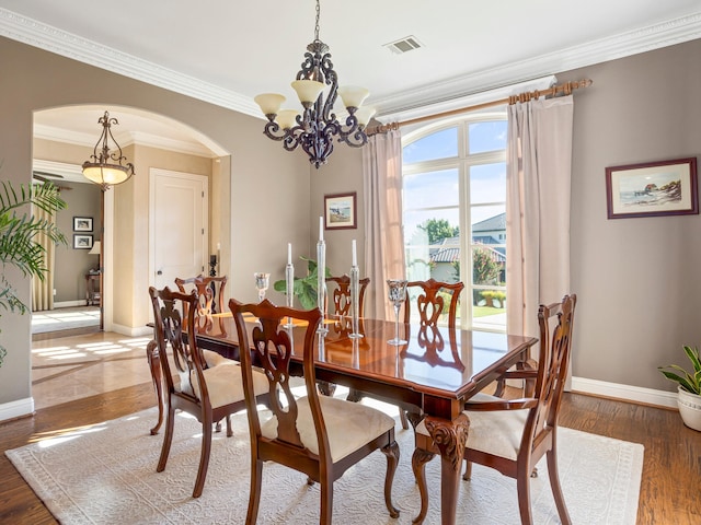 7005 Shinnecock Hills Dr, Fort Worth, TX 76132 - dining area featuring baseboards, a chandelier, arched walkways, visible vents, and wood finished floors