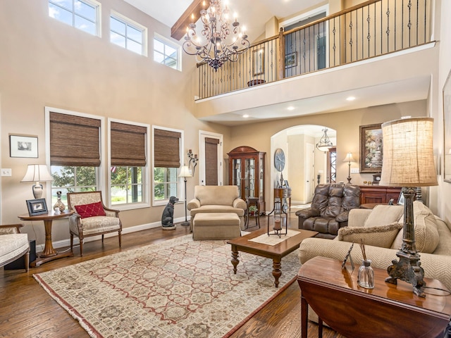 living room with a notable chandelier, a high ceiling, and hardwood / wood-style floors