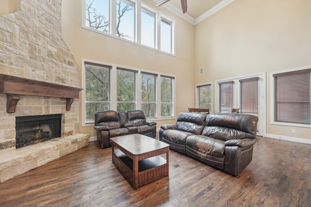 living room featuring ceiling fan, ornamental molding, a fireplace, and dark hardwood / wood-style flooring