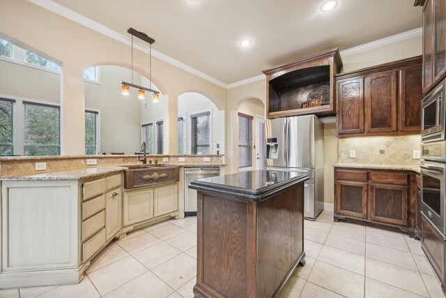 kitchen featuring dark brown cabinets, sink, stainless steel appliances, light tile patterned floors, and cream cabinets