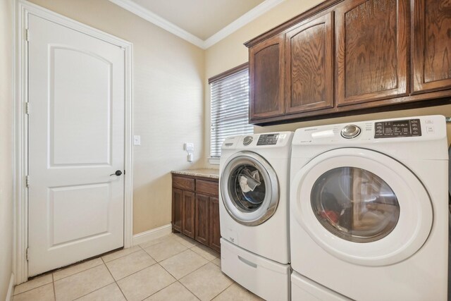 laundry area with cabinets, crown molding, light tile patterned floors, and washing machine and clothes dryer