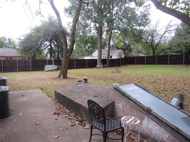 exterior space with a yard, a fenced backyard, and central AC