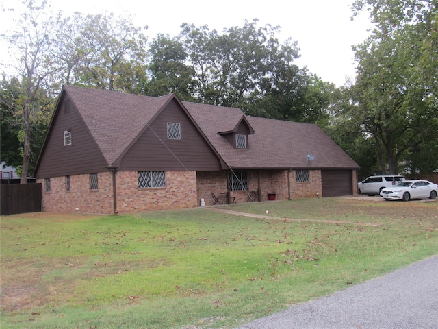 view of front of property with brick siding, a garage, and a front yard