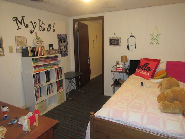 bedroom featuring a textured ceiling and dark hardwood / wood-style floors