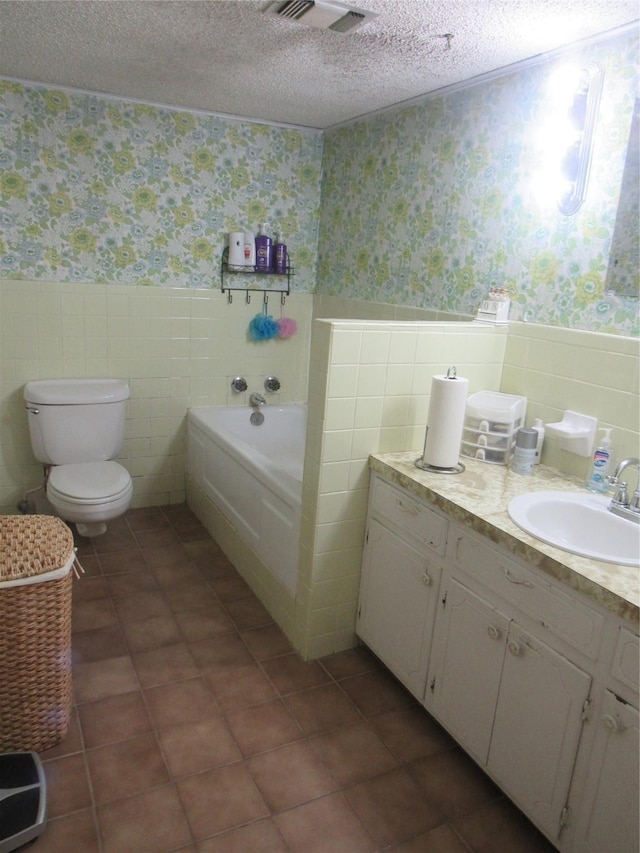 full bathroom featuring a textured ceiling, wainscoting, and wallpapered walls