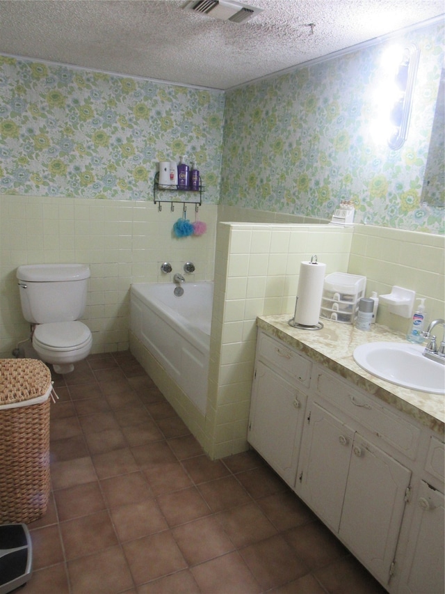 bathroom featuring tile walls, a textured ceiling, toilet, and a bathing tub