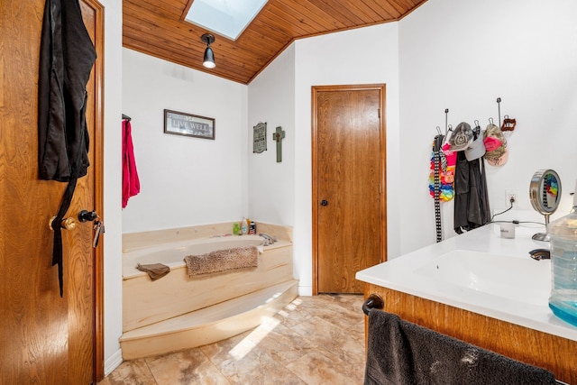 bathroom with a washtub, wood ceiling, vanity, and lofted ceiling with skylight