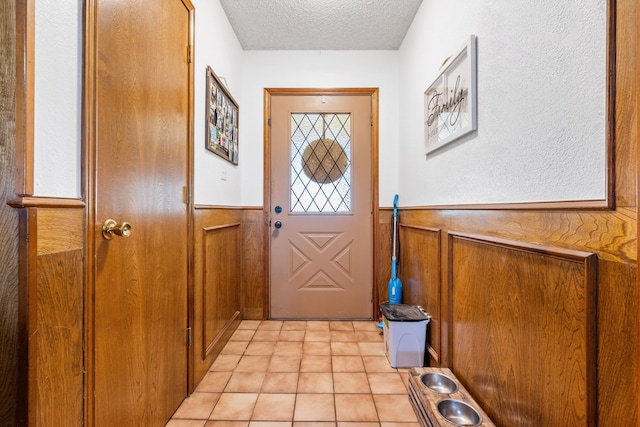 entryway featuring light tile patterned floors and a textured ceiling