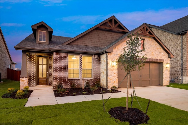 view of front of home featuring a garage and a yard