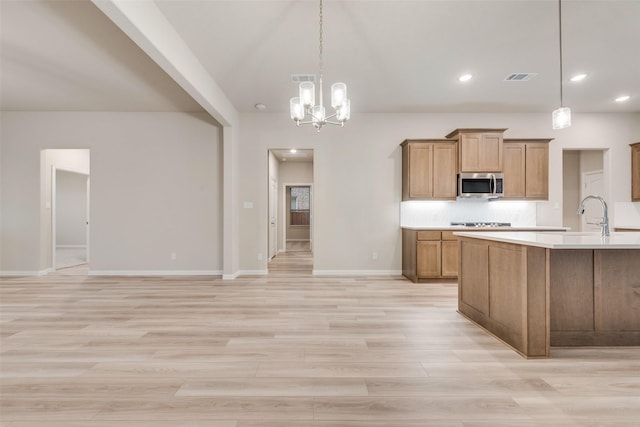 kitchen featuring an inviting chandelier, sink, hanging light fixtures, and light hardwood / wood-style flooring