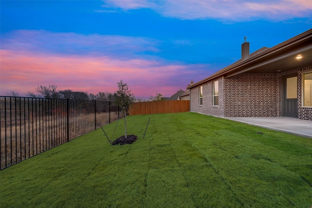 yard at dusk with a patio area