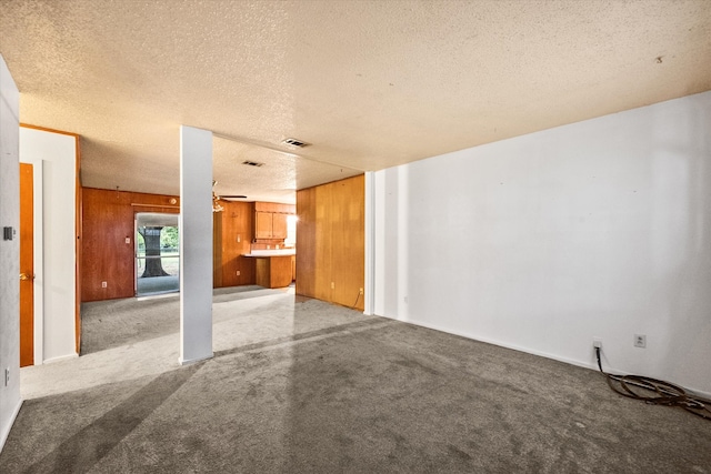 unfurnished living room with a textured ceiling and carpet flooring