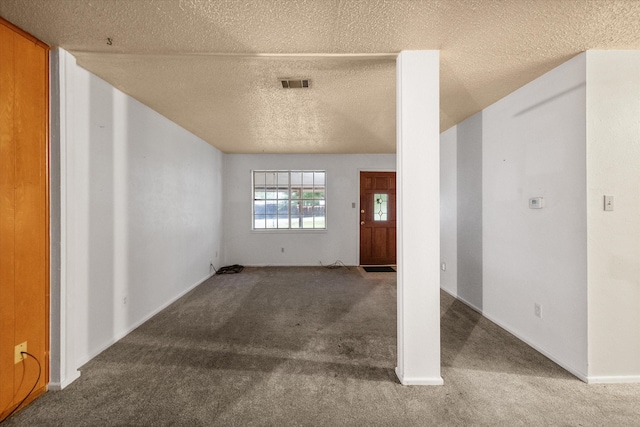 foyer entrance with a textured ceiling and carpet