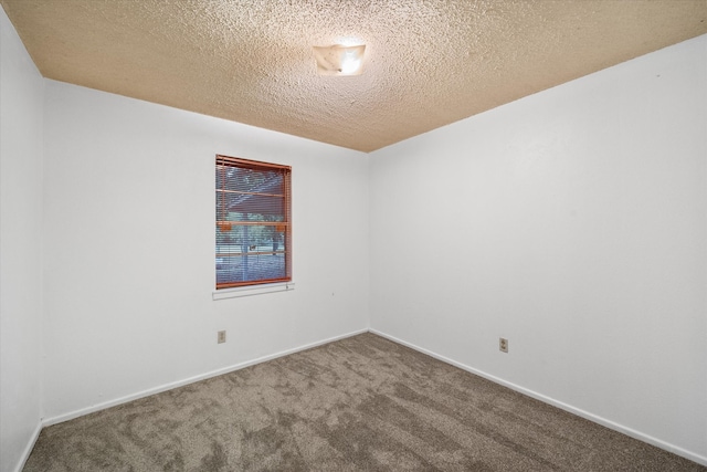 carpeted empty room with a textured ceiling