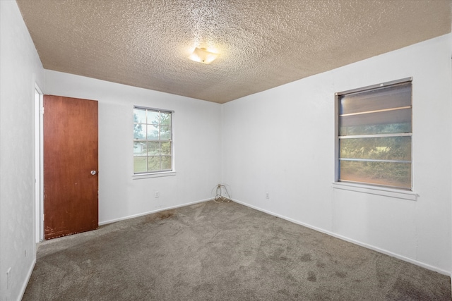 carpeted empty room with a textured ceiling