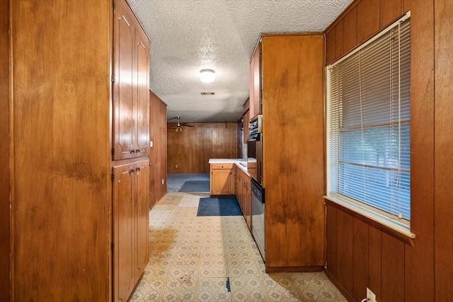 interior space featuring a textured ceiling and wood walls