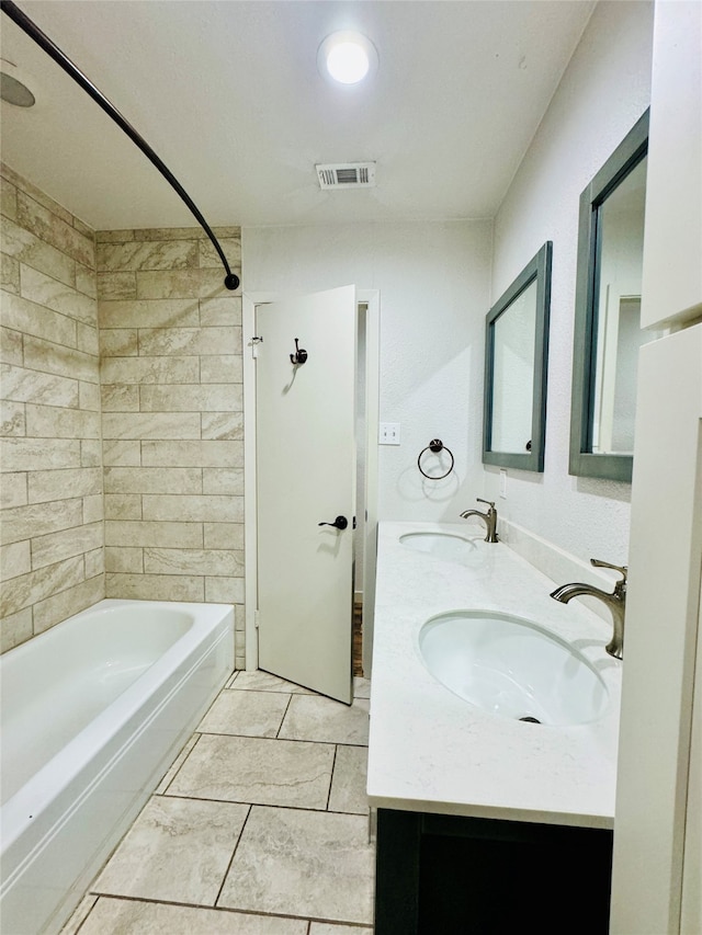 bathroom featuring vanity, tile patterned floors, and tiled shower / bath