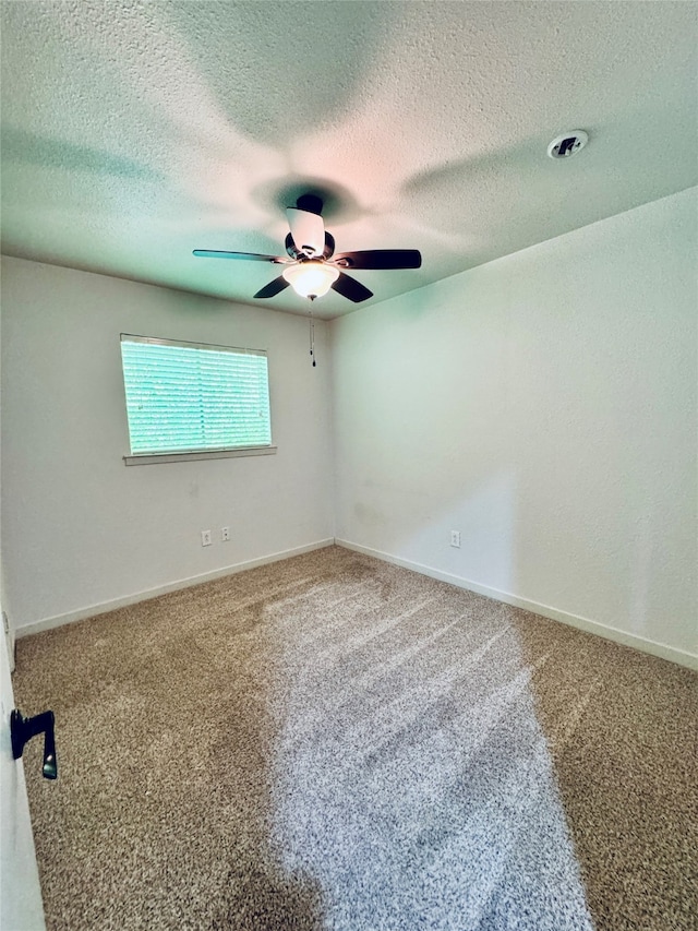 carpeted empty room featuring ceiling fan and a textured ceiling