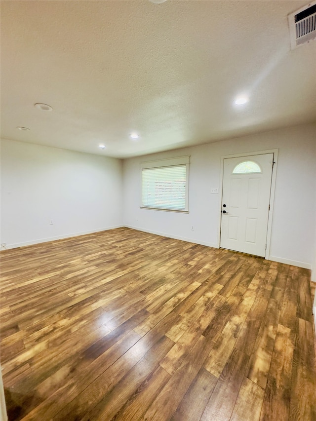 empty room featuring a textured ceiling and hardwood / wood-style floors