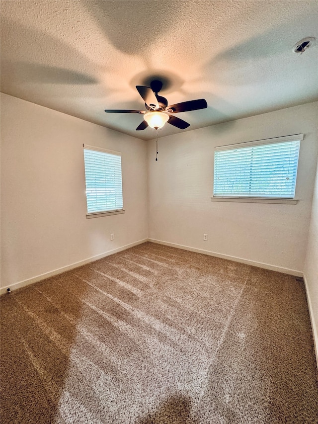 empty room featuring ceiling fan, carpet flooring, and a textured ceiling