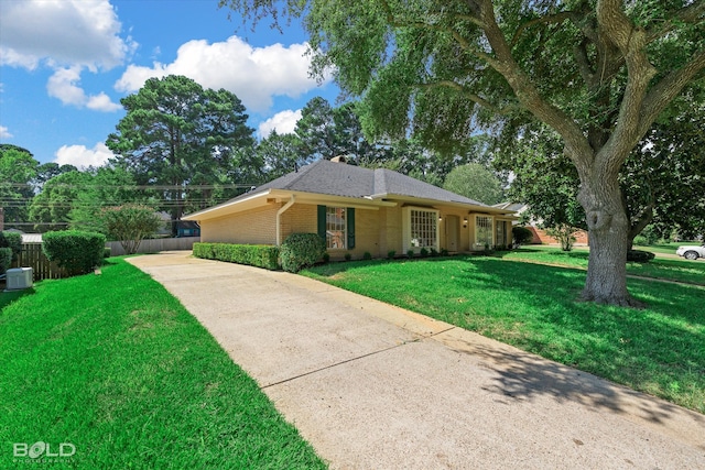 ranch-style house featuring cooling unit and a front lawn