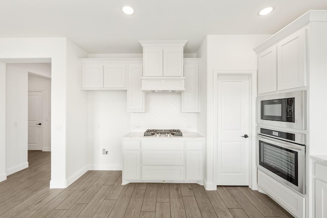 kitchen featuring backsplash, white cabinets, and appliances with stainless steel finishes