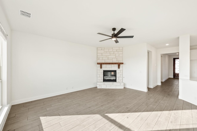 unfurnished living room with a fireplace, light hardwood / wood-style floors, and ceiling fan