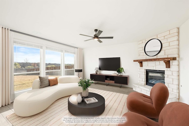 living room featuring ceiling fan and a fireplace