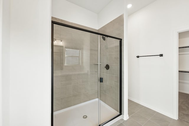 bathroom featuring tile patterned floors and a shower with shower door