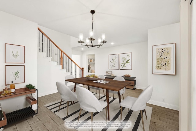 dining space with hardwood / wood-style flooring and an inviting chandelier