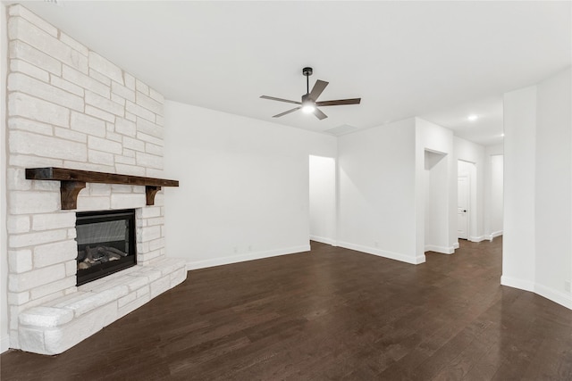 unfurnished living room featuring ceiling fan, dark wood-type flooring, and a fireplace