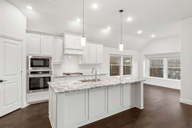 kitchen featuring stainless steel appliances, an island with sink, white cabinets, and decorative light fixtures