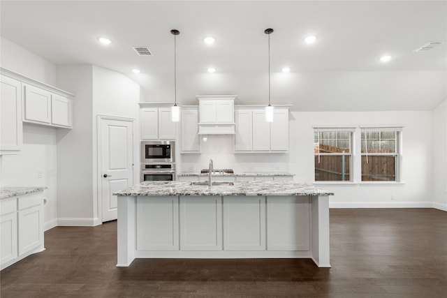 kitchen with built in microwave, stainless steel oven, hanging light fixtures, light stone countertops, and white cabinets