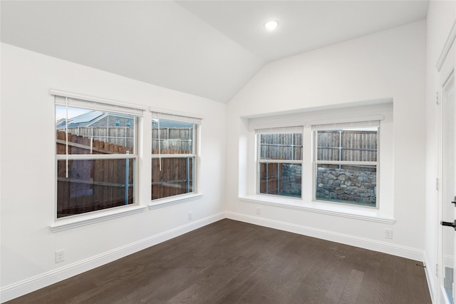 empty room with dark hardwood / wood-style flooring and vaulted ceiling