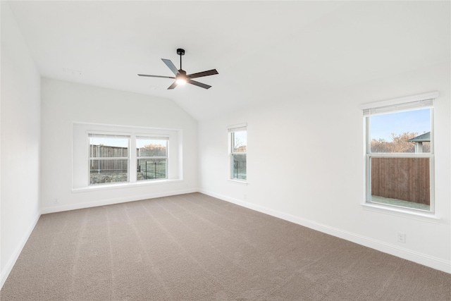 carpeted spare room with lofted ceiling, a wealth of natural light, and ceiling fan