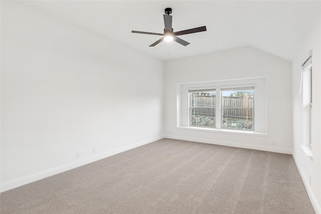 empty room featuring ceiling fan, carpet flooring, and vaulted ceiling