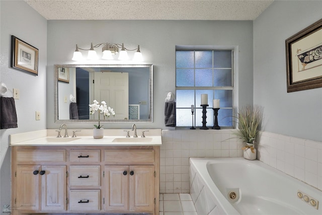 bathroom with a bathing tub, tile patterned flooring, vanity, and a textured ceiling