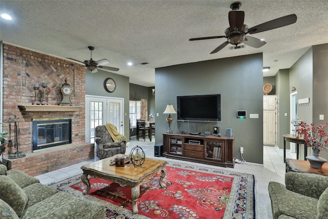 living room featuring ceiling fan, light tile patterned floors, a textured ceiling, and a brick fireplace